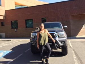 Picture of one of our members standing in front of her truck